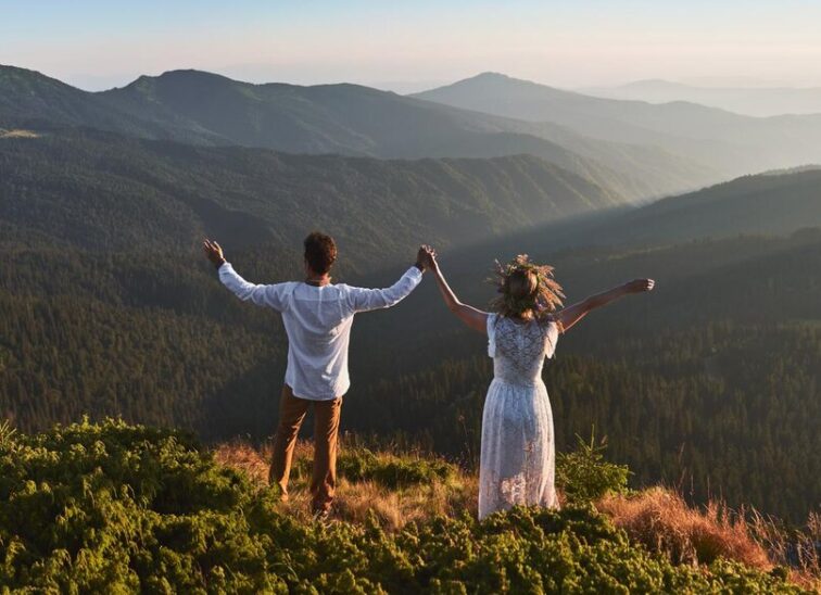 couple-is-holding-hands-top-mountain_651396-3477